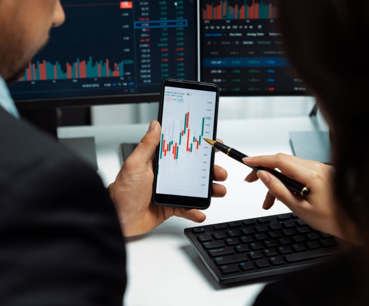 Two people looking at investment performance on a phone.