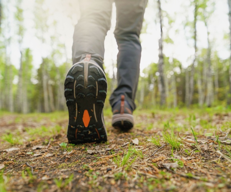 A close-up of a person walking in the woods.