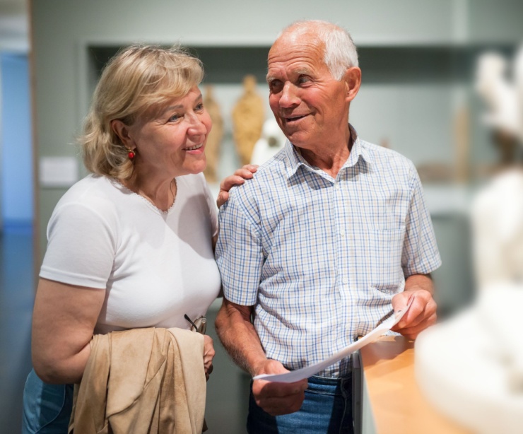 A couple looking at a statue in a museum.