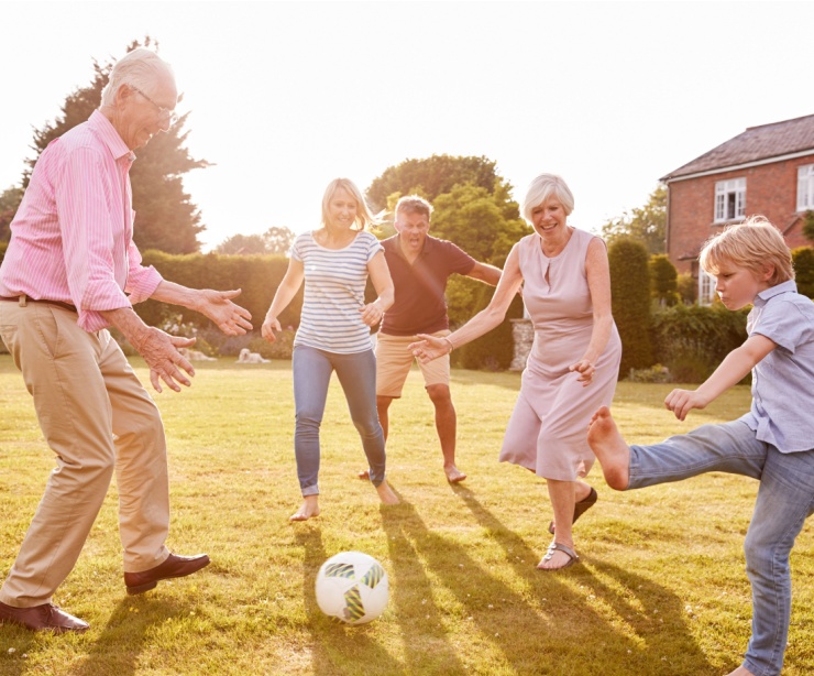 A family playing football in a garden.