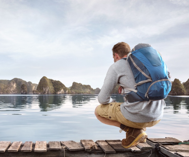 Traveller crouching on a jetty.