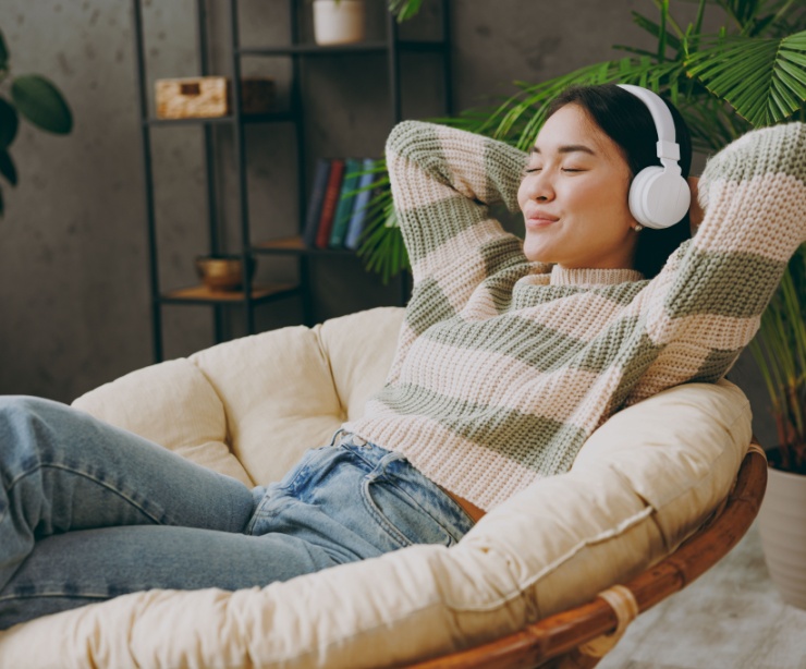 A woman relaxing with headphones on.