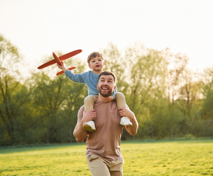 A father with a child sitting on his shoulders.