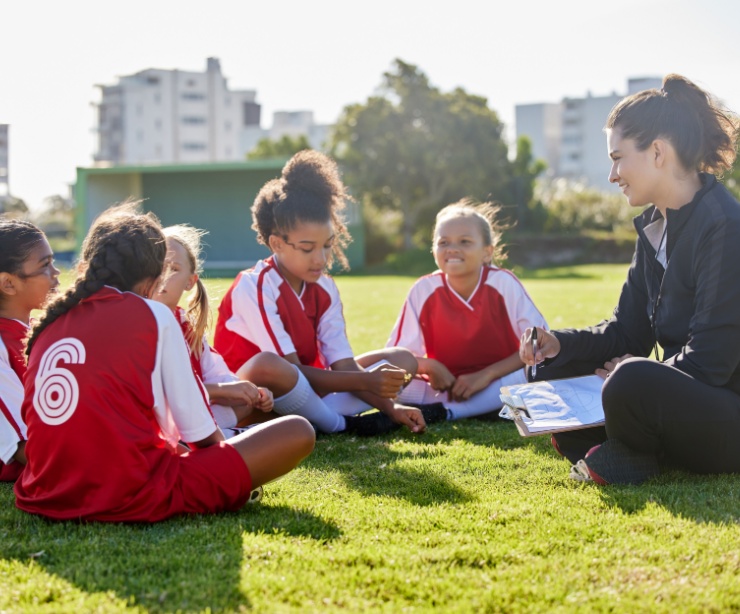 A woman coaching a girl’s football team.