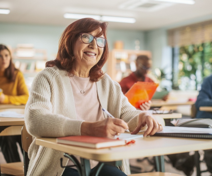 Happy senior woman taking notes in a classroom