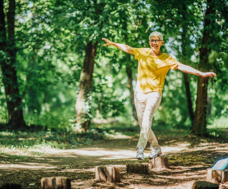 A woman doing balancing exercises outdoors.