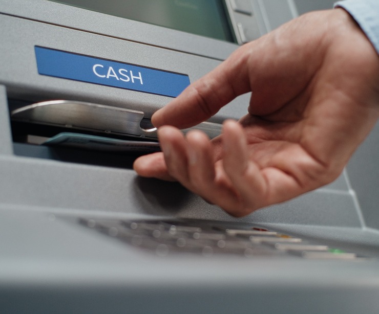 A person using an ATM to withdraw cash.