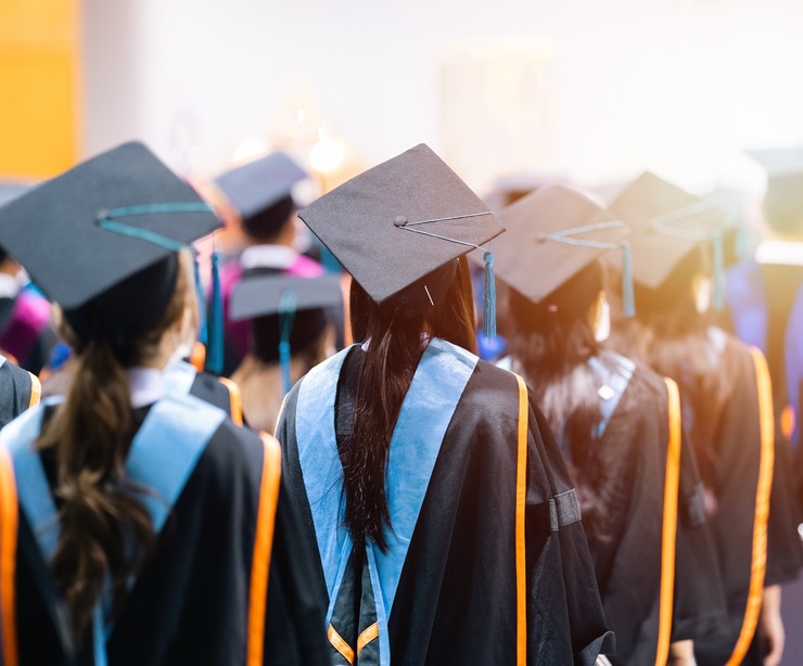 University students graduating wearing caps and gowns.