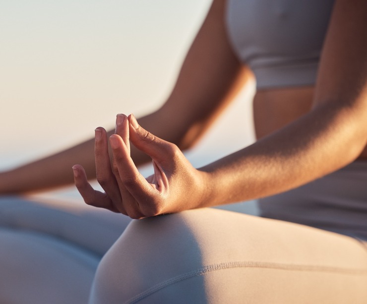 A woman sitting in the lotus position mediating.