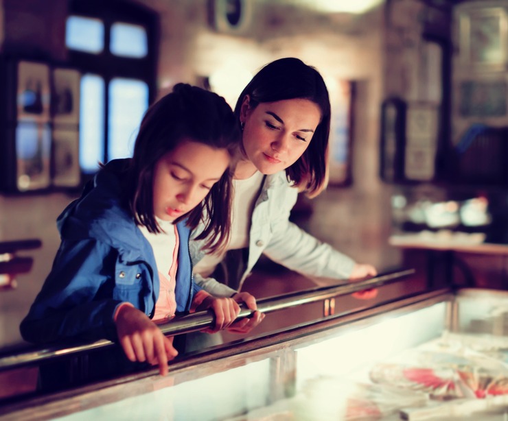 A mother and daughter viewing a museum exhibit.