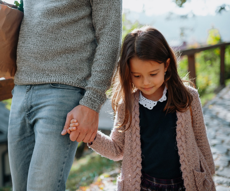 A mother and daughter holding hands.