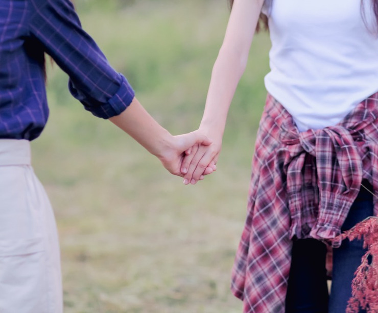 Two women holding hands.