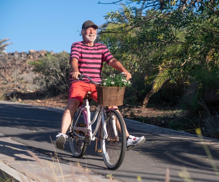 Happy senior man riding a bicycle