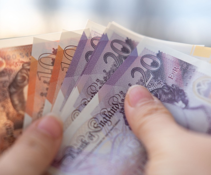 A person holding UK bank notes.