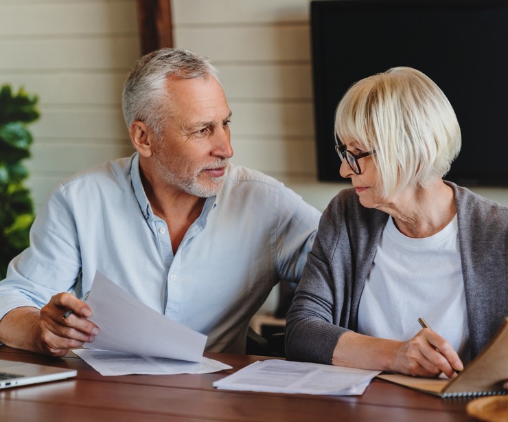 A mature couple talking and looking at paperwork together